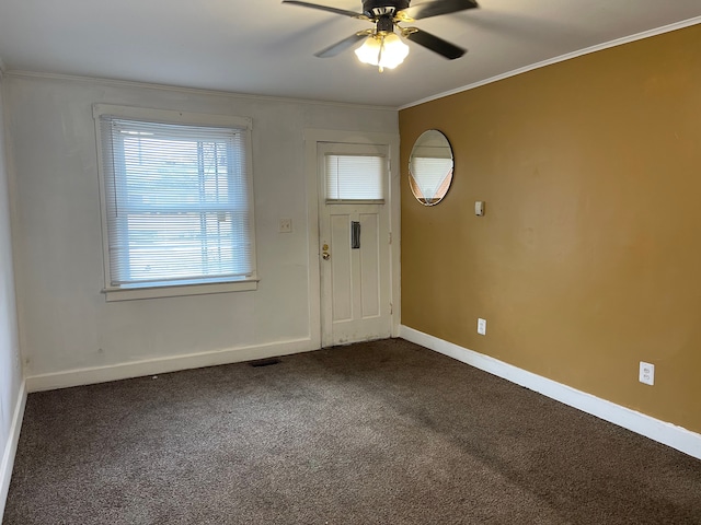 carpeted foyer entrance featuring crown molding and ceiling fan