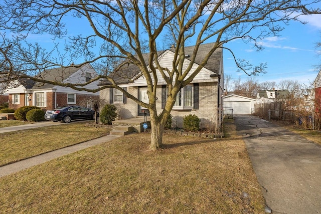 view of front of house featuring a garage, an outdoor structure, and a front lawn