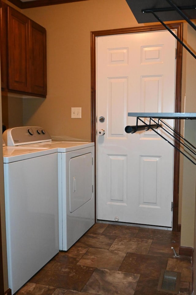 laundry area with independent washer and dryer and cabinets