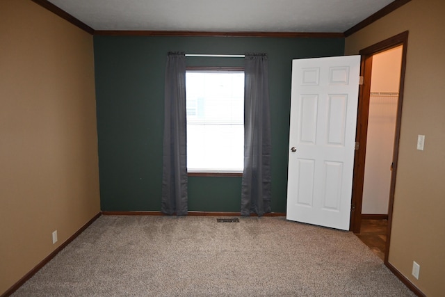 carpeted empty room featuring ornamental molding