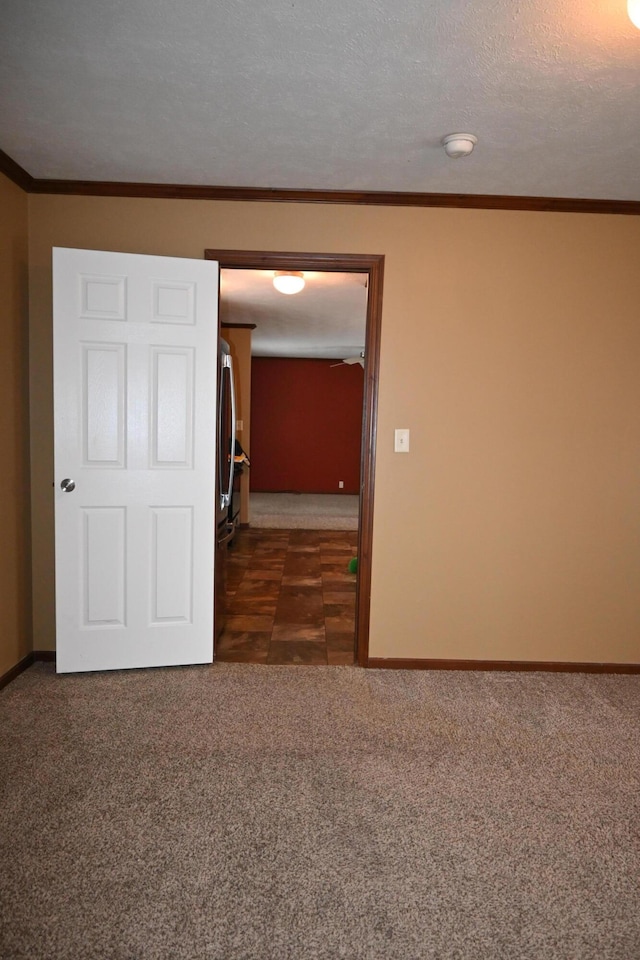 carpeted spare room with ornamental molding and a textured ceiling