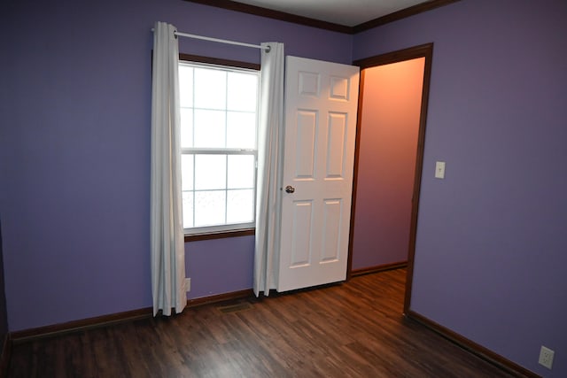 unfurnished room with dark wood-type flooring and crown molding