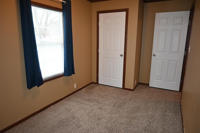 unfurnished bedroom featuring light colored carpet and multiple windows