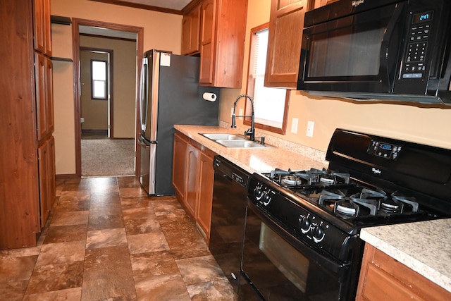 kitchen with ornamental molding, sink, a wealth of natural light, and black appliances