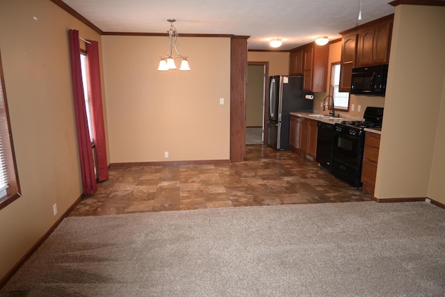 kitchen featuring pendant lighting, carpet flooring, sink, black appliances, and crown molding