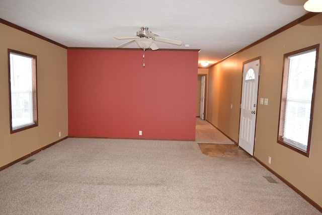 carpeted empty room with crown molding and ceiling fan