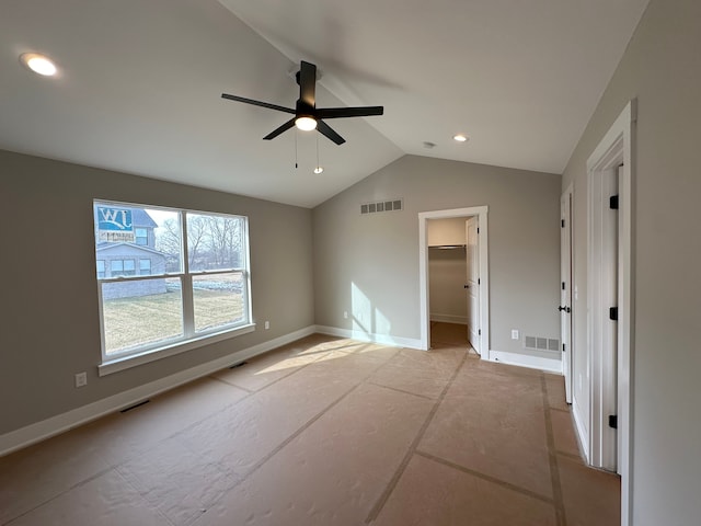 unfurnished bedroom with ceiling fan, a walk in closet, and lofted ceiling