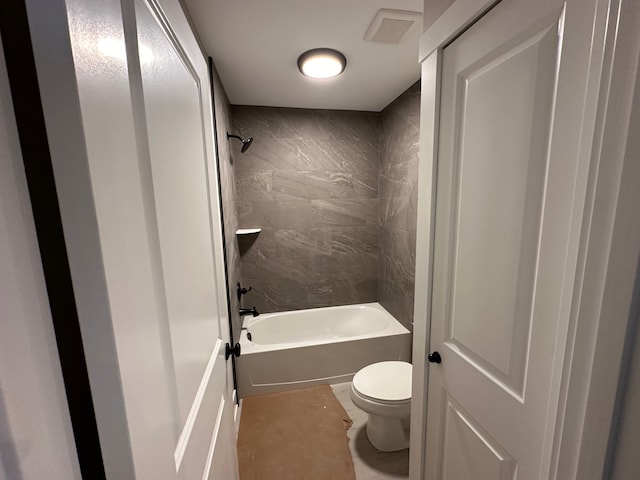 bathroom featuring tiled shower / bath and toilet