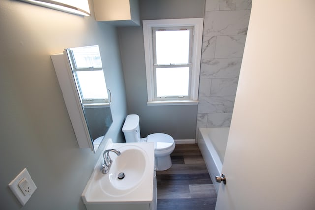 bathroom featuring vanity, toilet, a bathing tub, and hardwood / wood-style floors