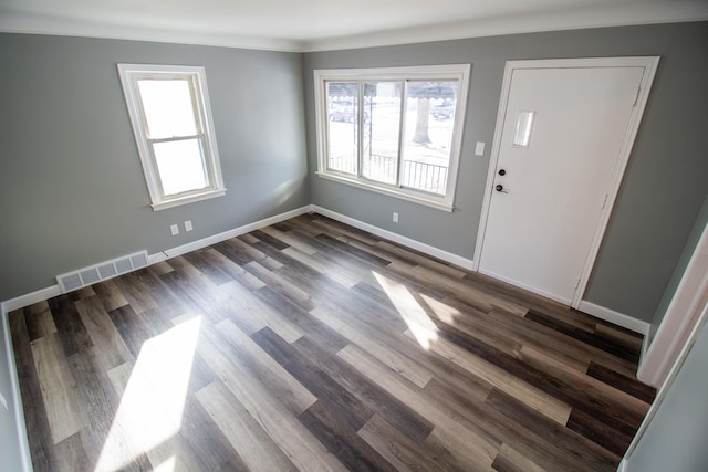 foyer featuring crown molding and dark hardwood / wood-style floors