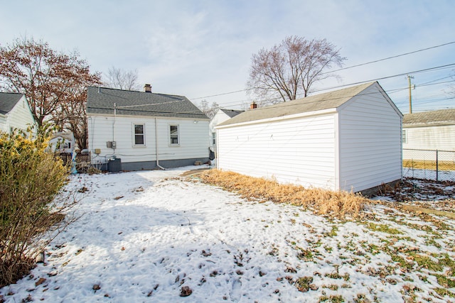 snow covered rear of property with central AC unit