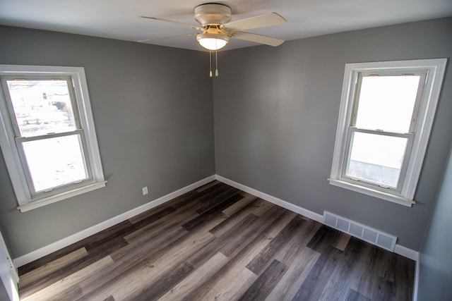 empty room with ceiling fan and dark hardwood / wood-style flooring