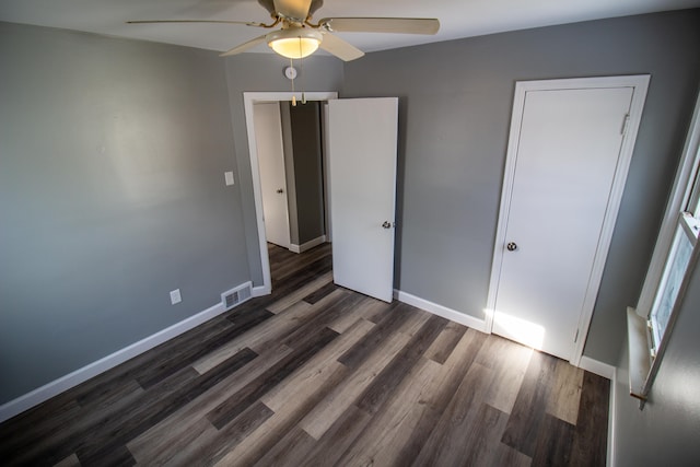 unfurnished bedroom featuring dark wood-type flooring and ceiling fan