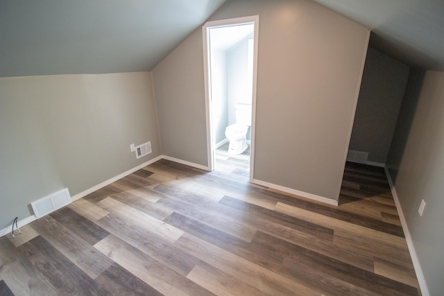 bonus room with wood-type flooring and vaulted ceiling