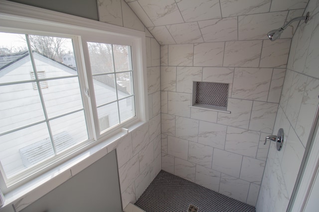 bathroom featuring plenty of natural light and tiled shower