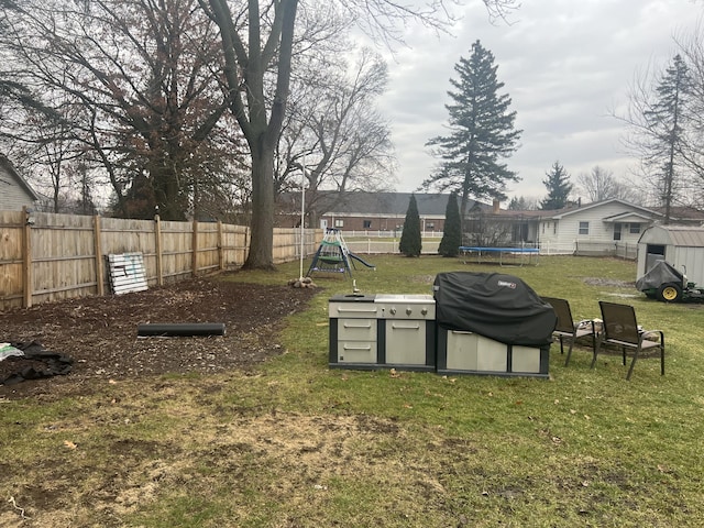 view of yard with a shed, a playground, and a trampoline