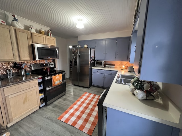 kitchen featuring light brown cabinetry, sink, gray cabinetry, light hardwood / wood-style flooring, and appliances with stainless steel finishes