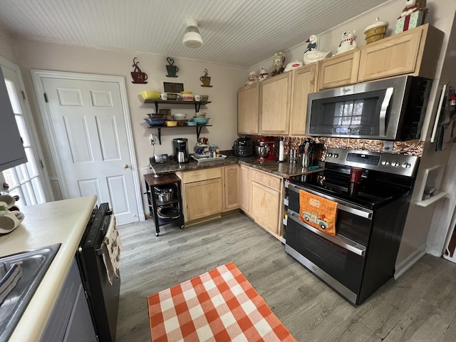 kitchen featuring stainless steel appliances, sink, light brown cabinetry, and light hardwood / wood-style floors