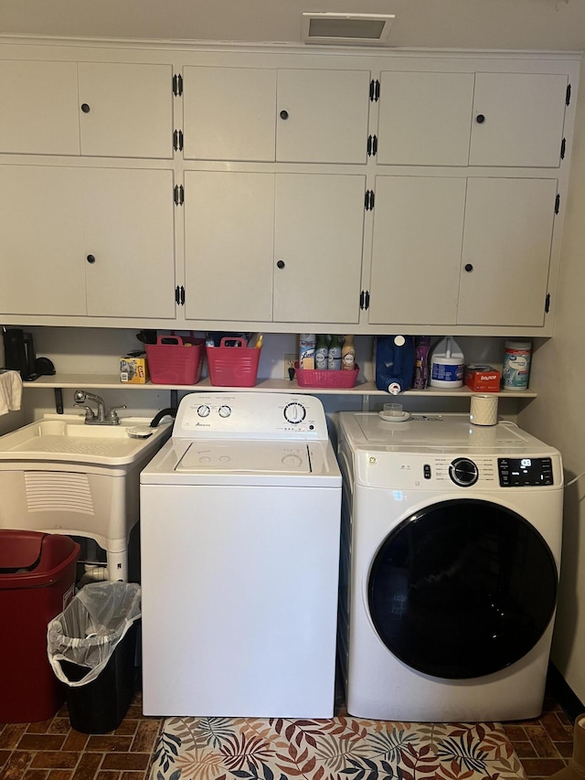 washroom featuring cabinets, sink, and independent washer and dryer