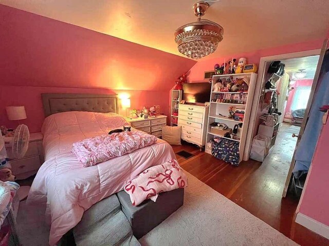 bedroom with dark wood-type flooring and vaulted ceiling