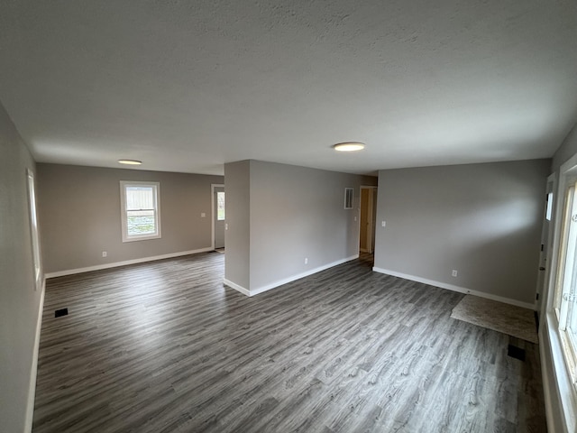 unfurnished room with dark hardwood / wood-style floors and a textured ceiling