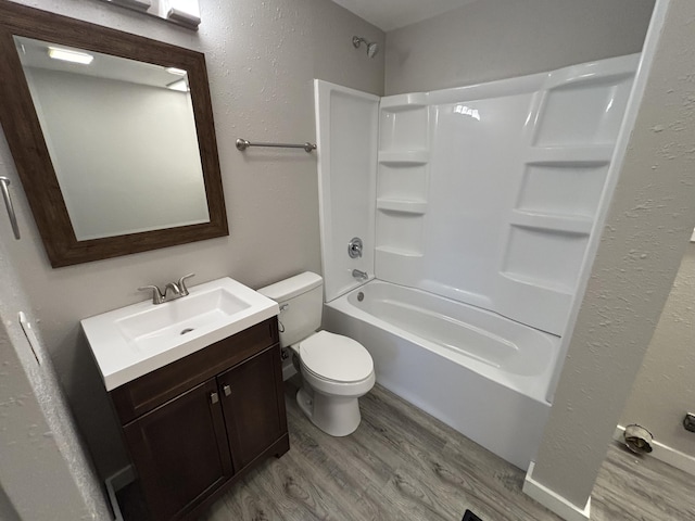 full bathroom featuring shower / washtub combination, hardwood / wood-style floors, vanity, and toilet