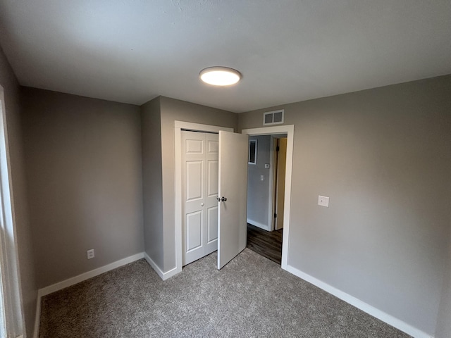 unfurnished bedroom with a closet and carpet flooring