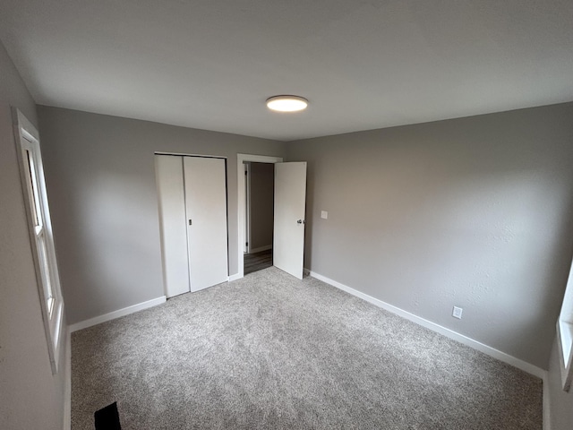 unfurnished bedroom with carpet flooring and a closet