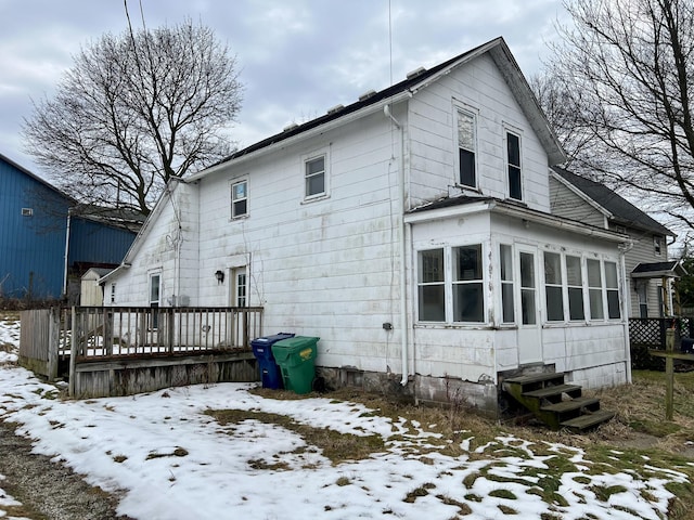 snow covered property with a deck