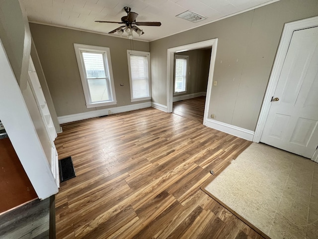 unfurnished living room featuring ceiling fan, ornamental molding, and hardwood / wood-style floors