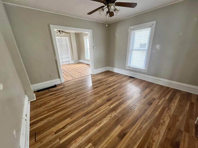 spare room with dark hardwood / wood-style flooring and ceiling fan