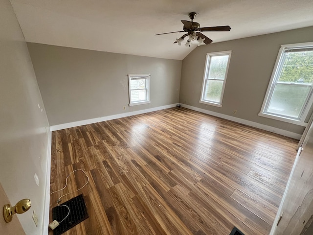 unfurnished room with hardwood / wood-style flooring, lofted ceiling, and a wealth of natural light