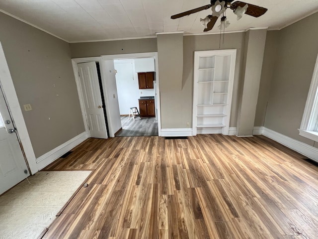 unfurnished living room with crown molding, dark wood-type flooring, and ceiling fan