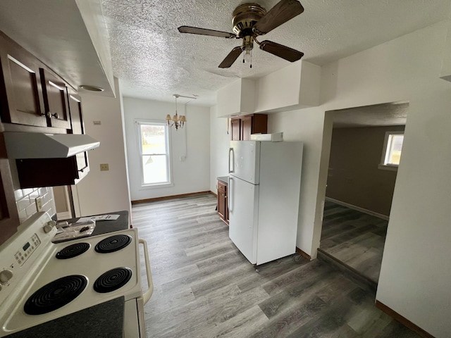 kitchen with white appliances, ceiling fan with notable chandelier, a textured ceiling, and light wood-type flooring