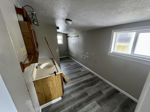 staircase with sink, hardwood / wood-style floors, and a textured ceiling