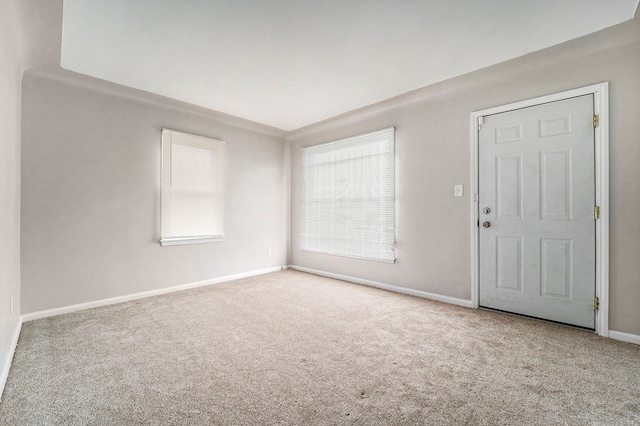 spare room featuring light carpet