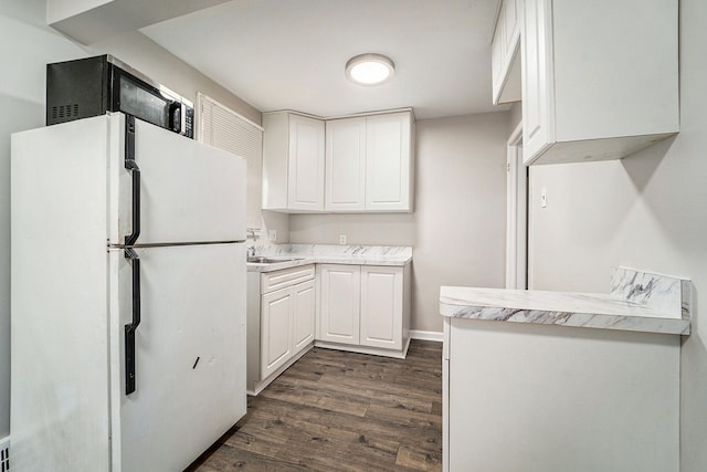 kitchen with white refrigerator, white cabinetry, dark wood-type flooring, and sink