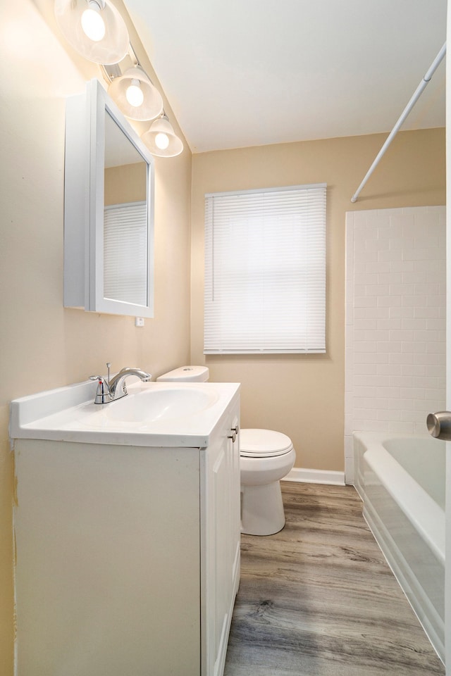 full bathroom featuring hardwood / wood-style flooring, vanity, toilet, and  shower combination