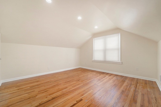 bonus room with vaulted ceiling and light hardwood / wood-style flooring