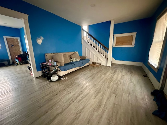 unfurnished living room featuring a wealth of natural light and hardwood / wood-style floors