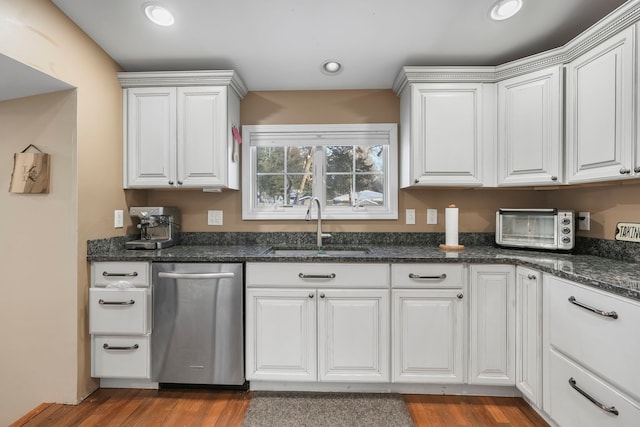 kitchen featuring stainless steel dishwasher, a sink, and white cabinets