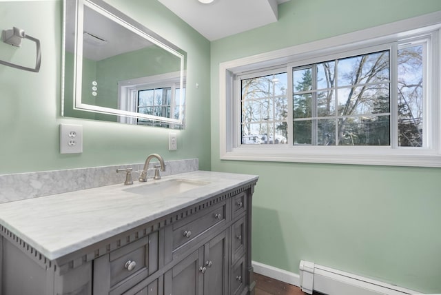 bathroom with a baseboard heating unit, vanity, and baseboards