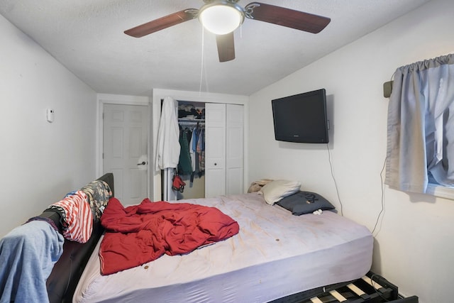 bedroom featuring vaulted ceiling, ceiling fan, a closet, and a textured ceiling