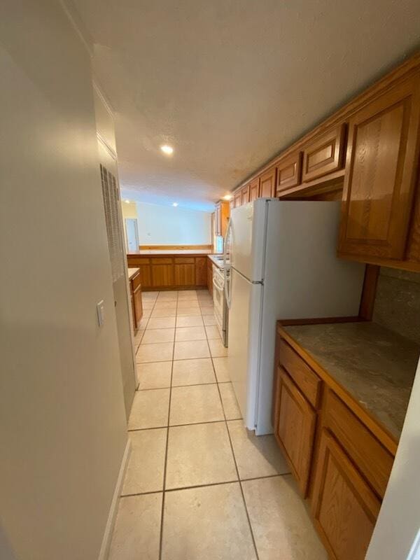 kitchen with white fridge and light tile patterned floors