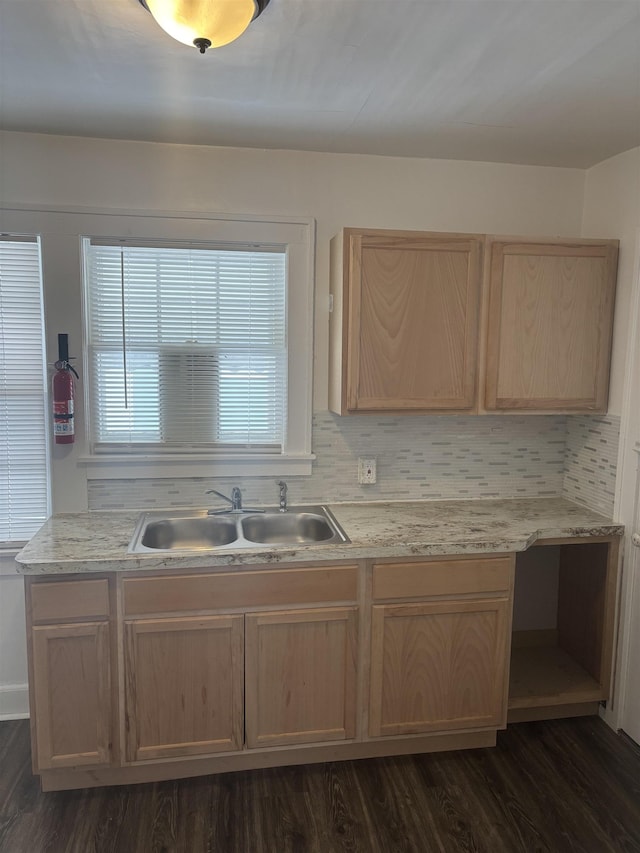 kitchen featuring a sink, light brown cabinets, decorative backsplash, and dark wood finished floors