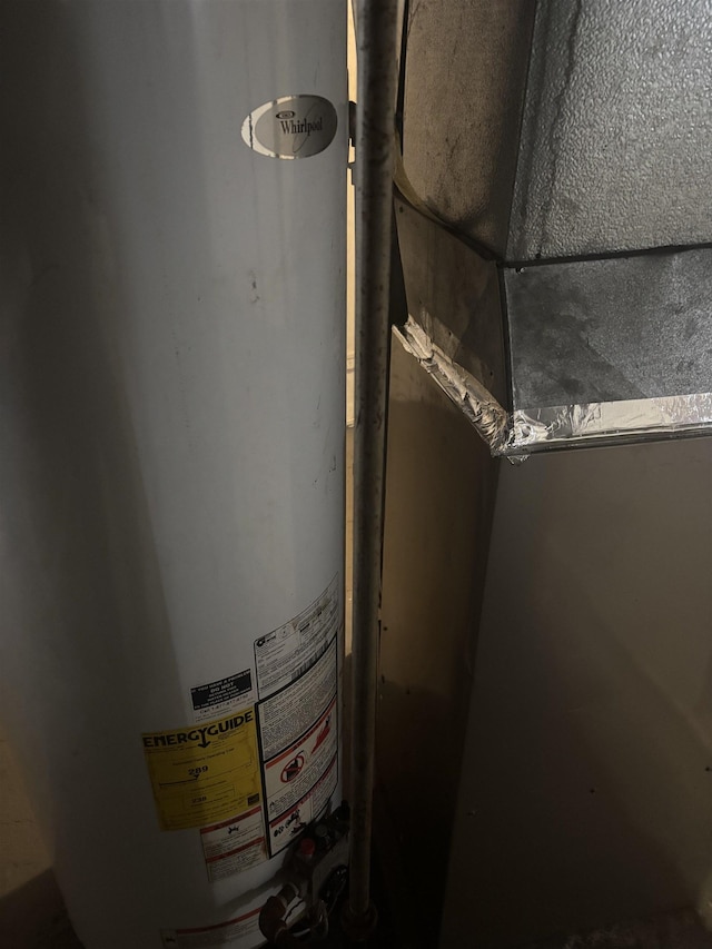 utility room with heating unit and water heater