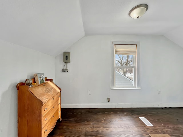 additional living space featuring vaulted ceiling and dark hardwood / wood-style flooring