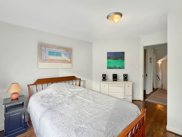 bedroom with dark hardwood / wood-style floors