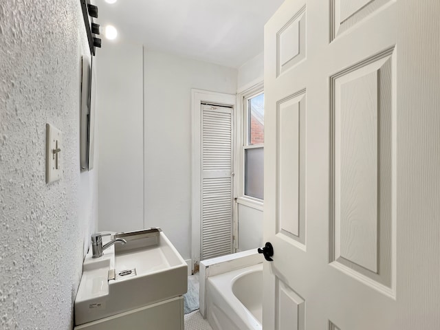 bathroom with vanity and a tub