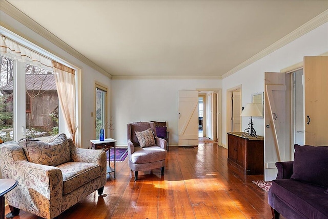 living area with hardwood / wood-style flooring and ornamental molding